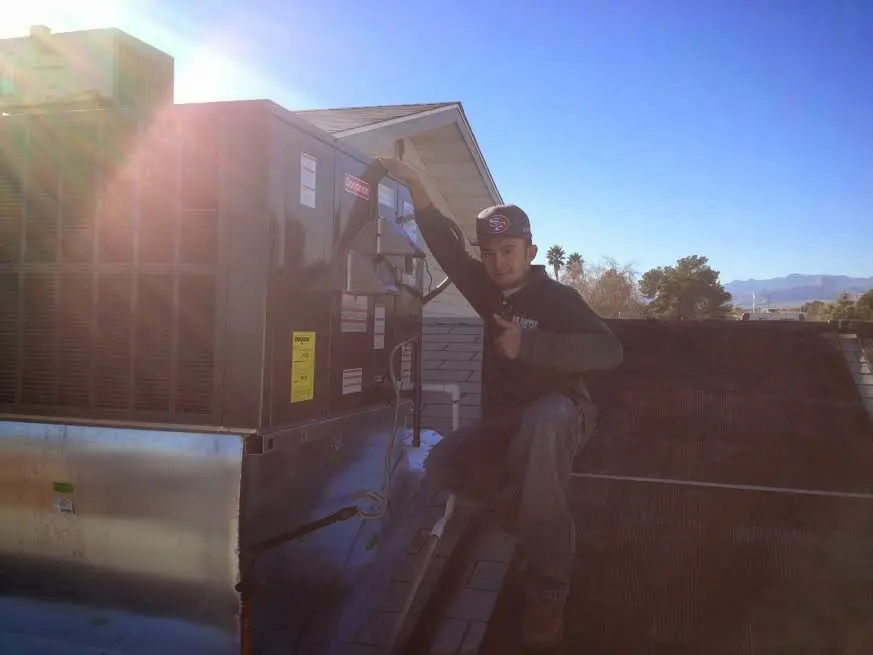 HVAC technician performing Boiler Repair on a rooftop unit in Ash